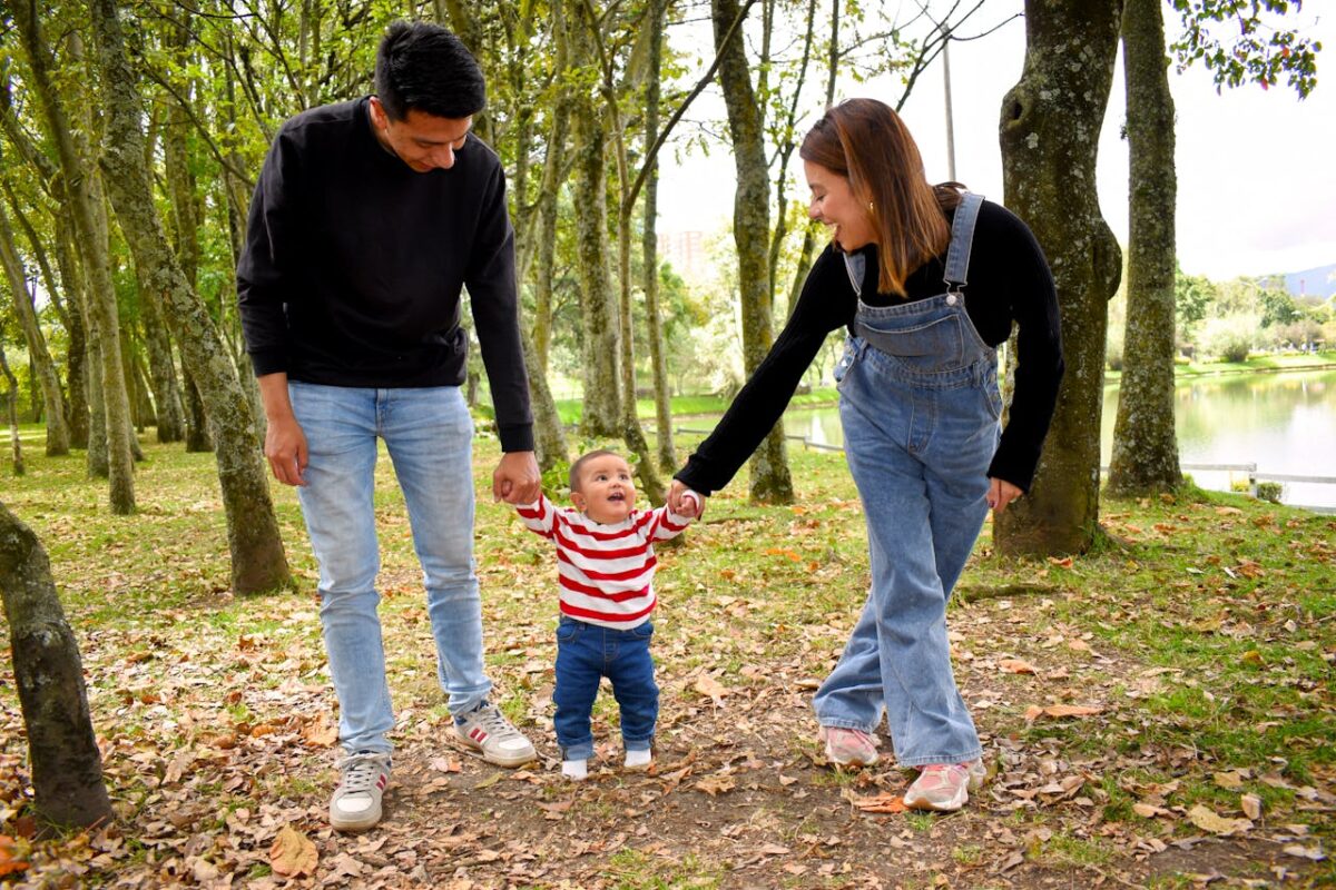A joyful family enjoys a walk under lush green trees in the park.